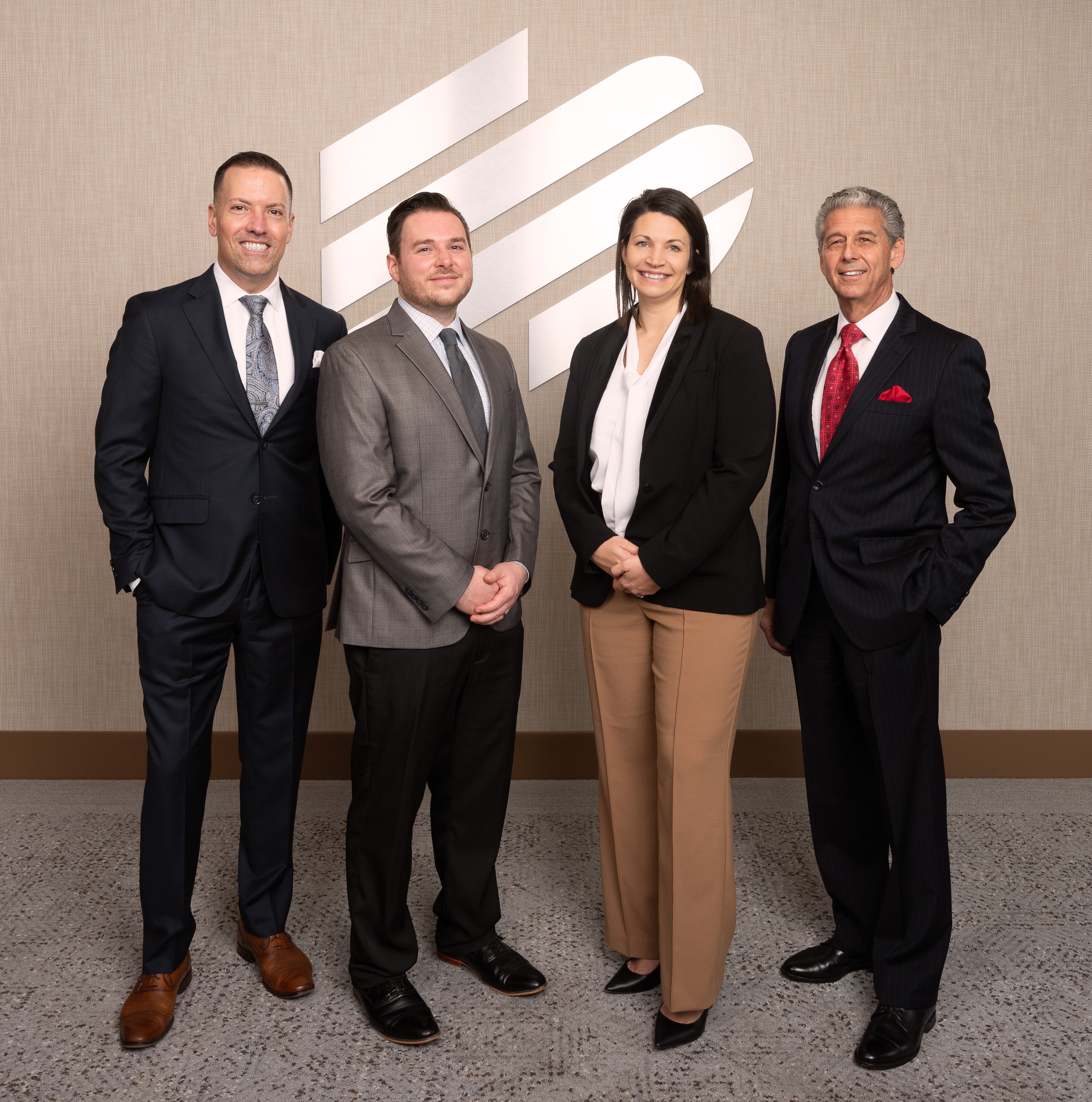 Four Enterprise Bank & Trust associates standing in front of logo, BAMSL