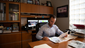 Man at desk looking through papers