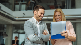 Two people in office discussing a file.