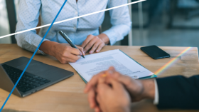 two men at a desk discussing closing business details