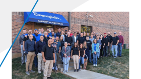 Swagelok team standing in front of sign on building