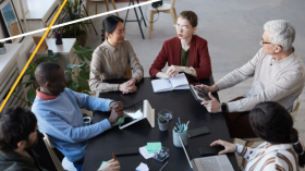 Group of people sitting at a conference table discussing Fraud Vulnerability